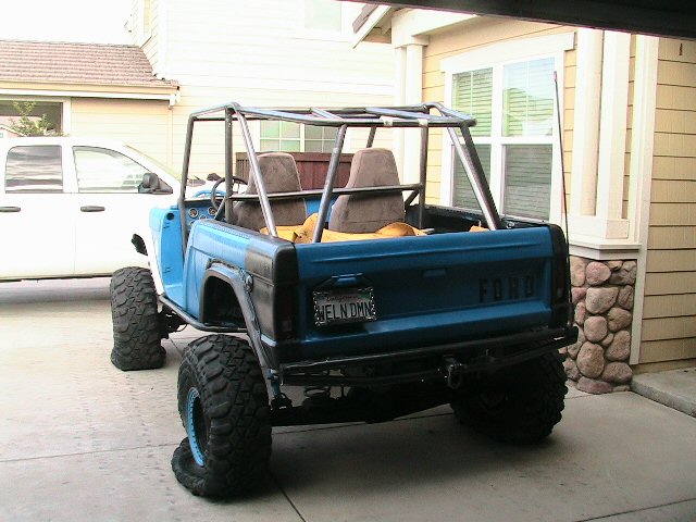 Blue 1971 Ford Bronco with roll cage, off-road tires, and custom rear bumper