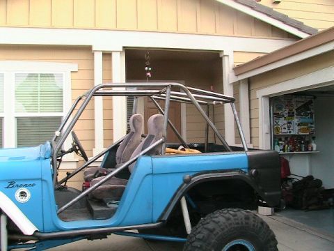 1971 Ford Bronco - This 1971 Ford Bronco features a custom roll cage and off-road modifications, seen from a three-quarter front perspective.