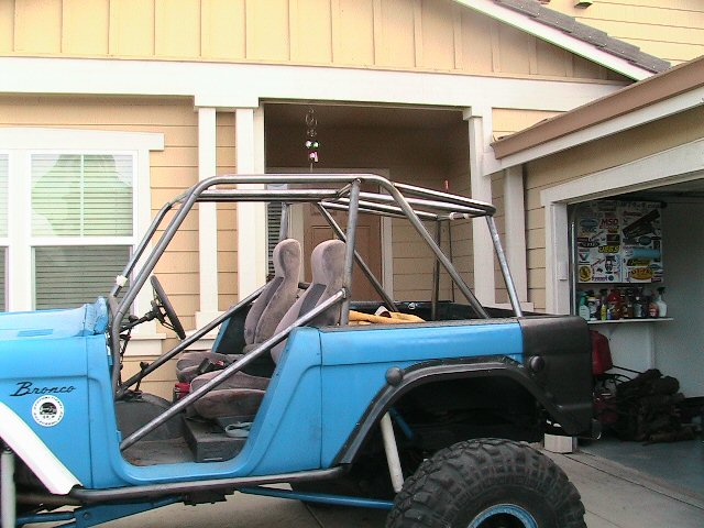 Blue 1971 Ford Bronco with roll cage and off-road tires, side view