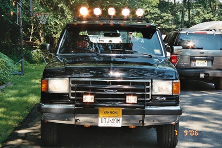 1991 Ford Bronco - A black Ford Bronco is parked in a driveway with a basketball hoop in the background.