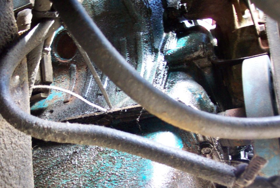 Close-up of engine components with hoses and some grime
