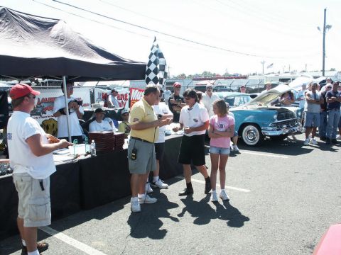 2001 Mercury Grand Marquis - A blue classic car, likely a 1955 model, is displayed with its hood open at an outdoor car show event.