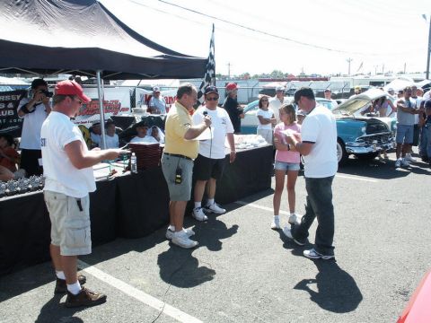 2001 Mercury Grand Marquis - A crowd gathers around a classic 1955 Chevrolet Bel Air at a car show, with people presenting awards.
