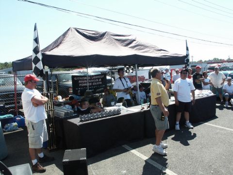 2001 Mercury Grand Marquis - An outdoor event with a tent set up, people mingling, and vehicles in the background.