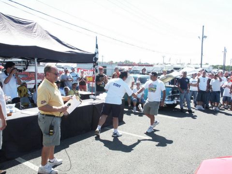 2001 Mercury Grand Marquis - Outdoor car show event with attendees and staff near a tent and awards table.