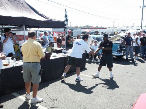 2001 Mercury Grand Marquis - A light blue car is visible at a car show, with staff members and attendees around.