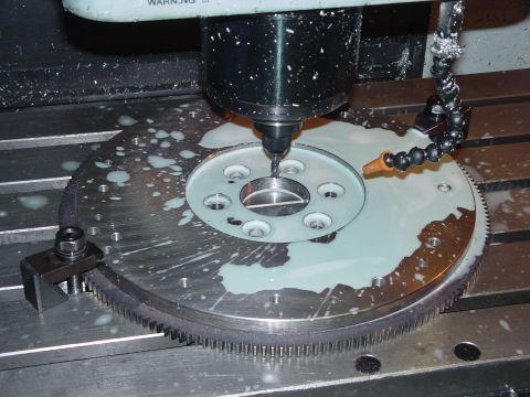 1979 Ford Bronco - Flywheel being machined on a CNC mill with coolant applied.