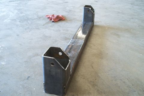 1983 Ford Bronco - A custom steel crossmember sits on a concrete floor next to a red rag.