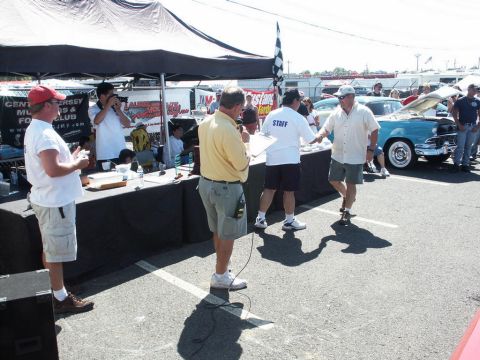 2001 Mercury Grand Marquis - A classic blue sedan is displayed with its hood open at a car show event.