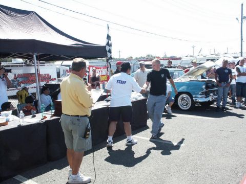 2001 Mercury Grand Marquis - A car show event with people receiving awards and a vintage car on display.
