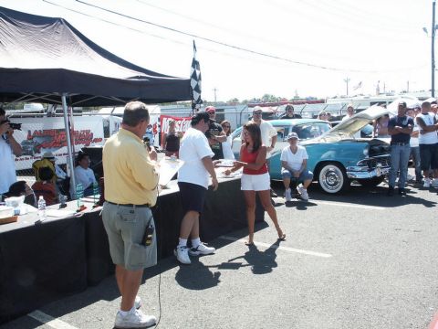 2001 Mercury Grand Marquis - A turquoise 1956 classic car is displayed with its hood open at a car show, drawing a crowd of onlookers.