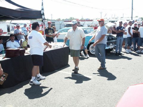 2001 Mercury Grand Marquis - A classic blue and white car is displayed at a car show with attendees milling around.