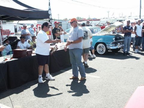 2001 Mercury Grand Marquis - Awards are being presented at a car show with a classic turquoise car in the background.