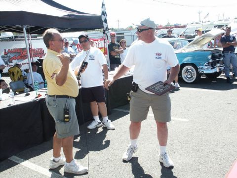 2001 Mercury Grand Marquis - A turquoise 1956 Ford Fairlane Crown Victoria is displayed at a car show with people around.
