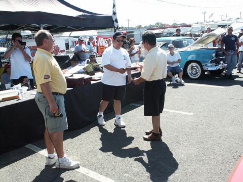 2001 Mercury Grand Marquis - Attendees interact at a car show event, with a vintage automobile visible.