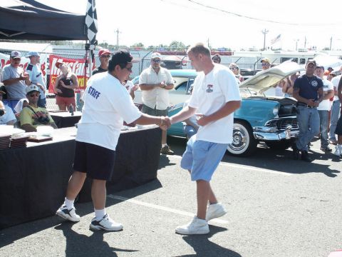 2001 Mercury Grand Marquis - A car show event with people gathered around a classic car, and an award ceremony taking place.