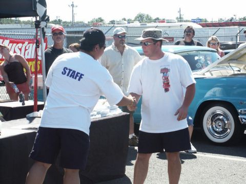 2001 Mercury Grand Marquis - People interact at an outdoor event with a classic car in the background.
