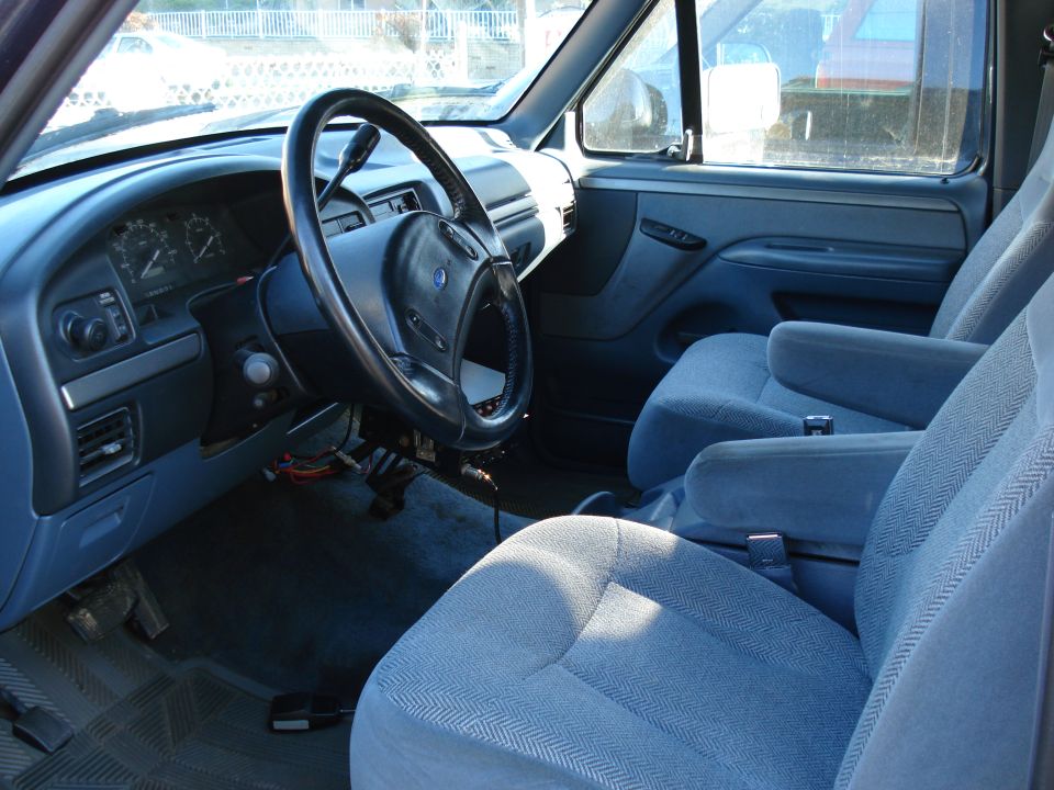 Interior of a 1994 Ford Bronco showing dashboard, steering wheel, and front seats
