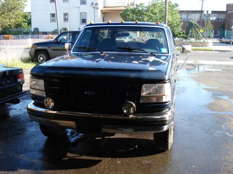 1994 Ford Bronco - Front view of a black 1994 Ford Bronco, showing its grille, headlights, and chrome bumper.