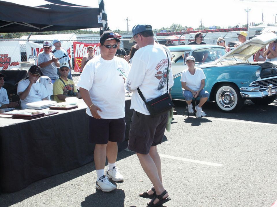 people at a car show with a turquoise and white classic car