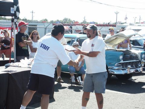 2001 Mercury Grand Marquis - A man is presented with an award at a car show, with several vintage vehicles visible in the background.