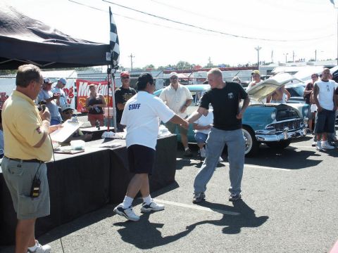 2001 Mercury Grand Marquis - An outdoor event with a tent, tables, and several classic cars on display, with attendees interacting.