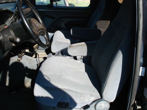 1994 Ford Bronco - Interior view of a truck's cabin, gray cloth seats and a dashboard with visible wiring.