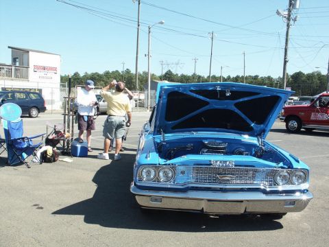 2001 Mercury Grand Marquis - A bright blue 1963 Ford Galaxie 500 is displayed with its hood open at an outdoor car show.
