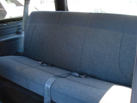 1994 Ford Bronco - Interior view of a vehicle's rear bench seat with blue patterned upholstery and seatbelts.