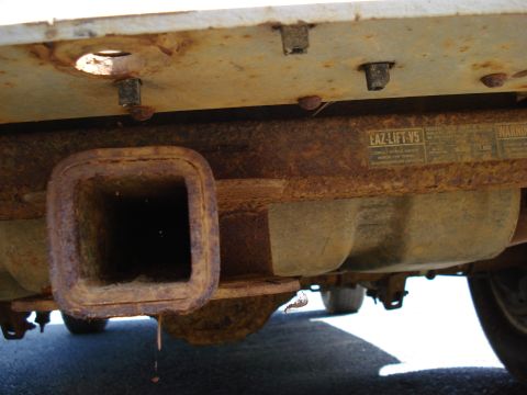 1994 Ford Bronco - Close-up of a heavily rusted trailer hitch receiver, showing a visible EAZ-LIFT V5 label.
