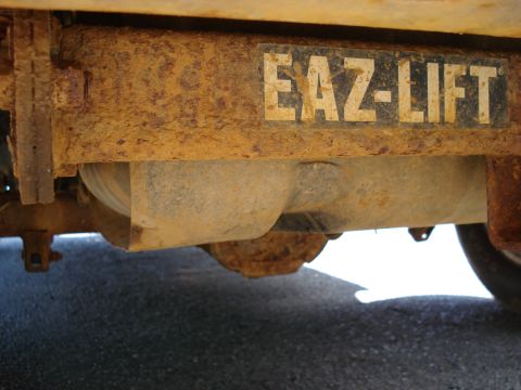 1994 Ford Bronco - Close-up of a heavily rusted trailer hitch component labeled EAZ-LIFT, showing significant wear and tear.