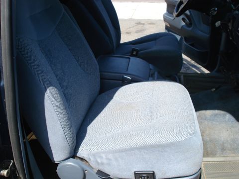 1994 Ford Bronco - The interior of a vehicle shows the front seats and center console, upholstered in a patterned fabric.