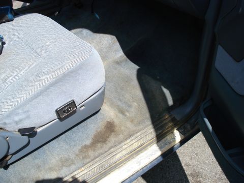 1994 Ford Bronco - Interior view of a car's passenger seat and floor, showing wear and tear.