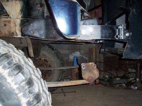 1983 Ford Bronco - Undercarriage view shows suspension and frame components, with a large off-road tire in the foreground.