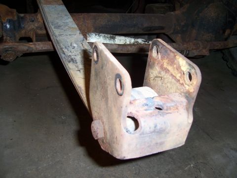 1983 Ford Bronco - Close-up view of a heavily rusted leaf spring bracket and U-bolt, likely from a truck or SUV chassis.