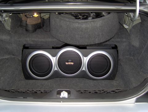 2002 Ford Crown Victoria - Trunk space with aftermarket subwoofer and spare tire. Boots are also stored in the trunk.