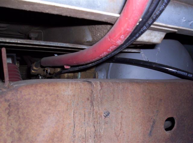 Red hose with 200 PSI W.P. marking, part of vehicle undercarriage