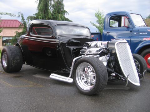 1979 Ford Bronco - A custom hot rod coupe with an exposed engine sits beside a vintage Dodge pickup truck.