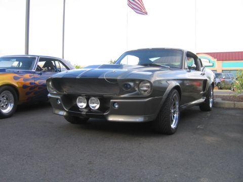 1979 Ford Bronco - A gray 1967 Shelby GT500 is parked next to a car with flame graphics.