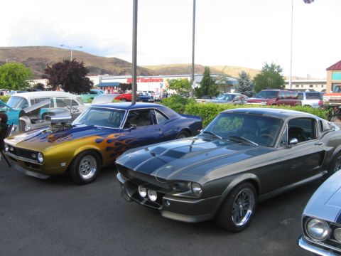 1979 Ford Bronco - Two iconic muscle cars, a 1967 Mustang and a custom Camaro, are displayed at an outdoor event.