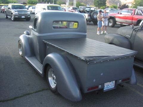 1979 Ford Bronco - A custom gray pickup truck with a tonneau cover is parked in a lot with other vehicles.