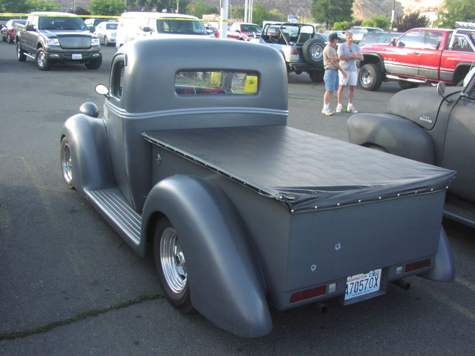 Gray hot rod pickup truck with a tonneau cover, rear view