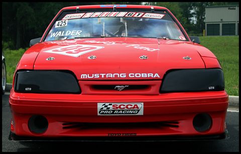 1993 Ford Mustang - Front view of a red 1993 Ford Mustang Cobra race car, displaying "Mustang Cobra" and SCCA Pro Racing decals.