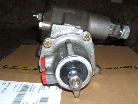 1988 Ford Bronco - A remanufactured recirculating-ball power steering gearbox in bare cast finish sitting on its cardboard shipping box, with the splined inpu…