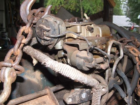 1966 Ford Ranchero - Close-up view of an engine carburetor assembly, suspended by chains.