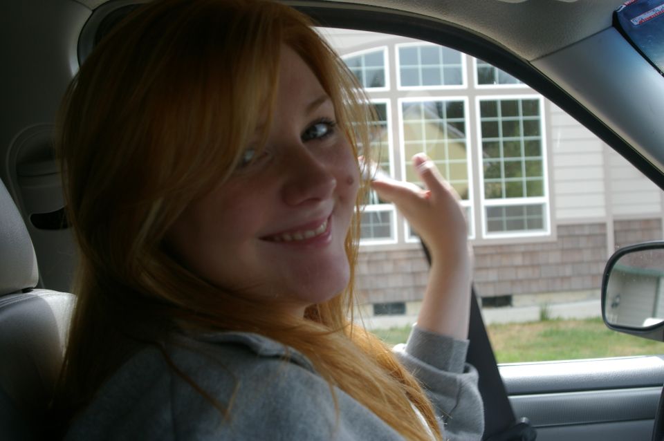 Woman in car interior, smiling