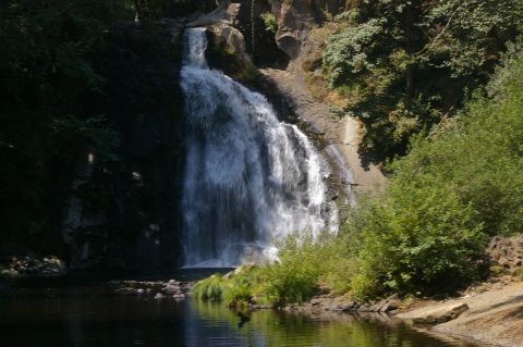 1998 Jeep TJ - Scenic view of a waterfall surrounded by dense foliage and a calm body of water.