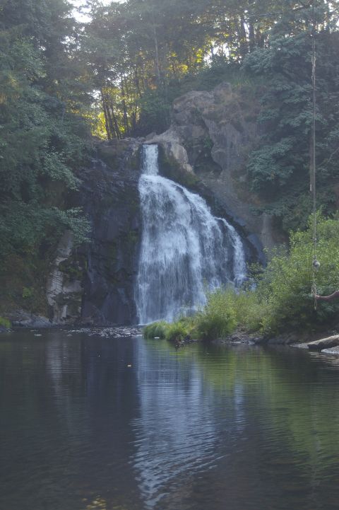 1998 Jeep TJ - A scenic view of a waterfall flowing into a tranquil river, with lush green trees in the background.