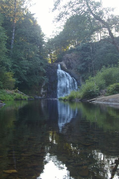 1998 Jeep TJ - A scenic view of a waterfall flowing into a river, surrounded by lush green trees.
