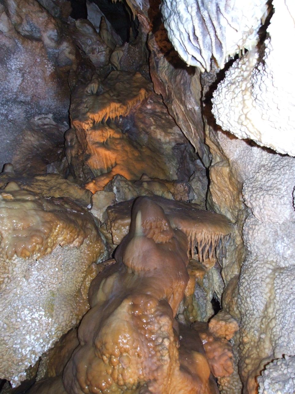 Cave interior with stalactites and stalagmites, water features